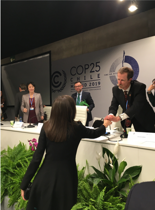 UN Special Rapporteur map of countries recognizing healthy environment as a human right shaking hands with the queen of spain at COP 25